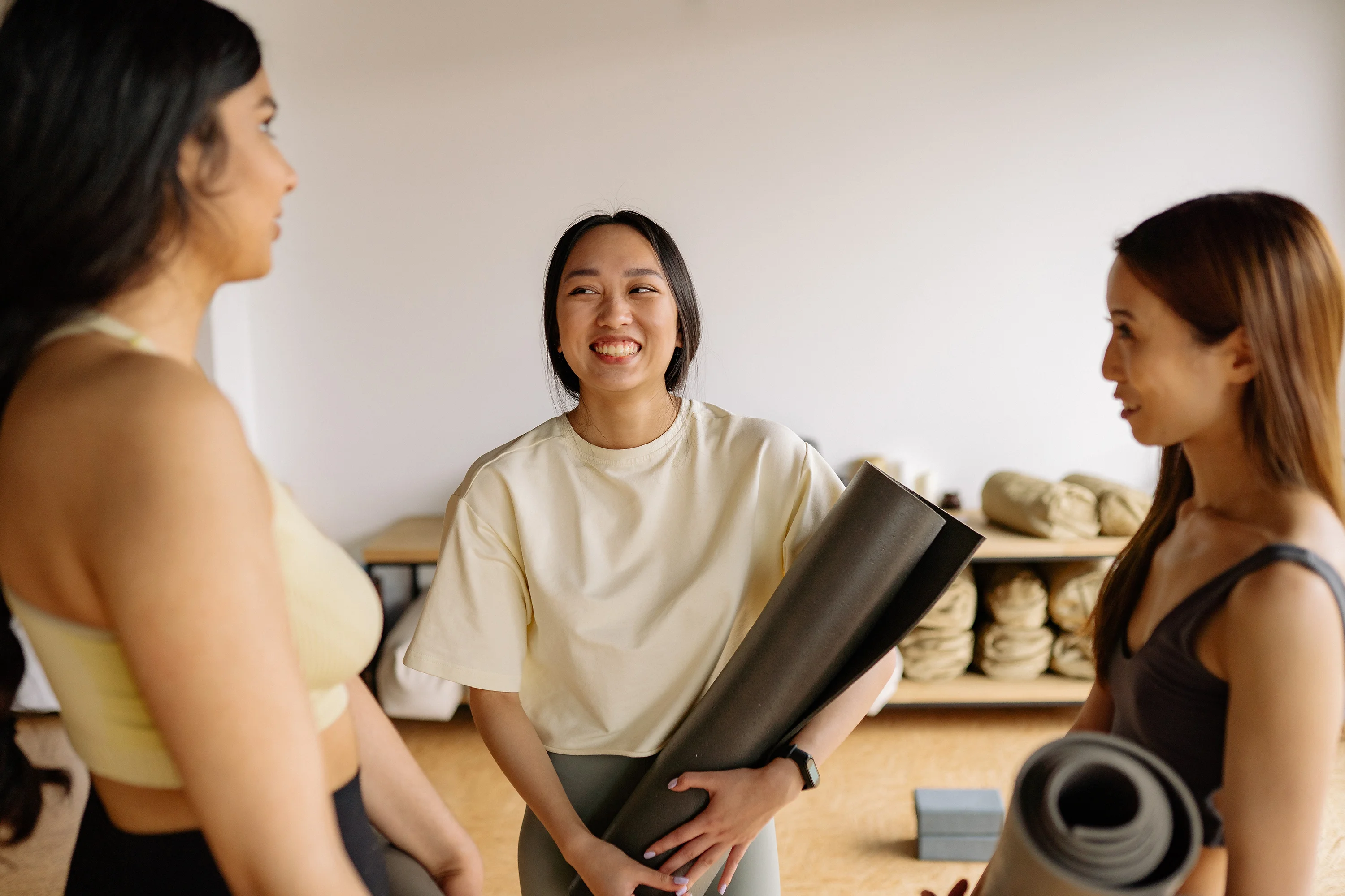 three women talking in a yoga class